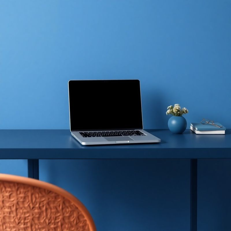 Minimalistički radni stol s otvorenim laptopom u indigo tonu
